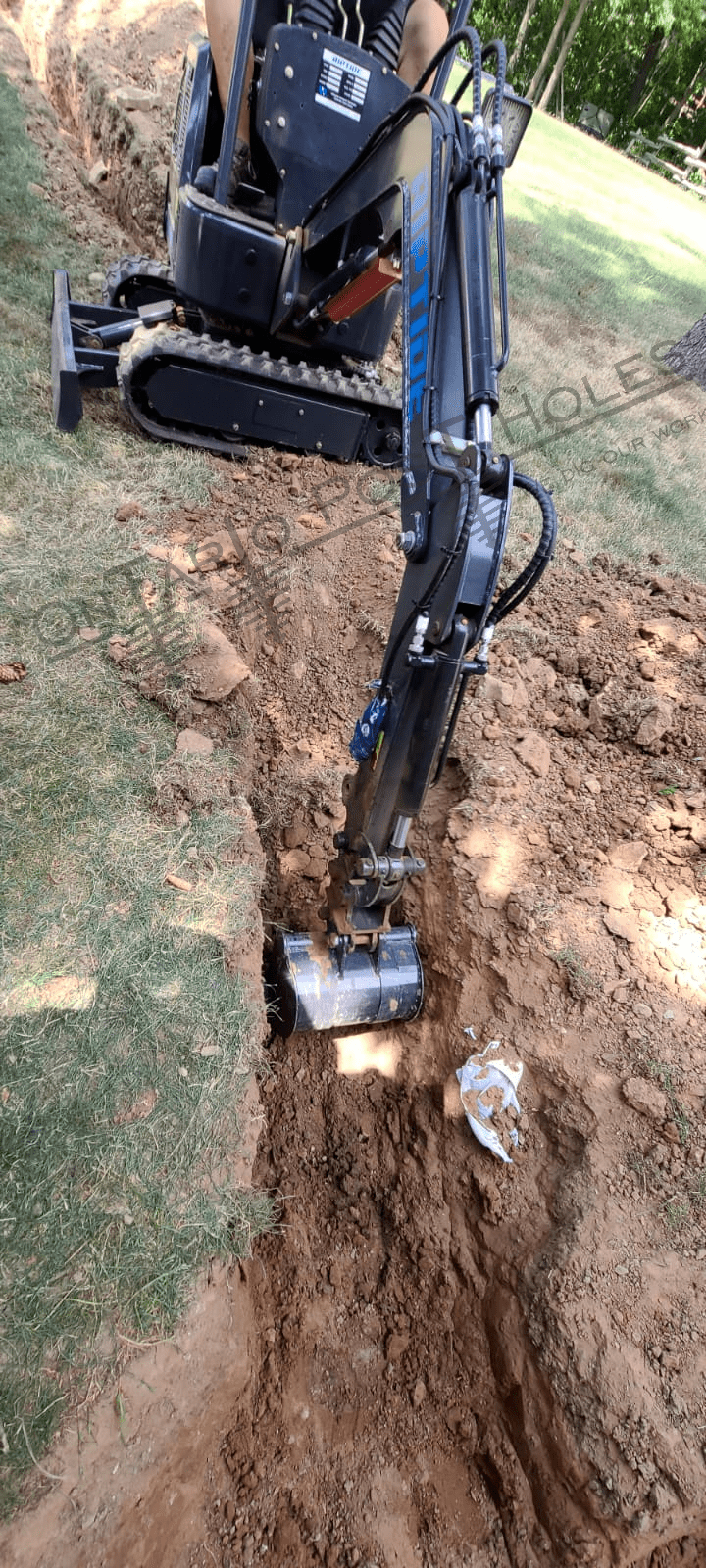 Mini excavator digging a hole