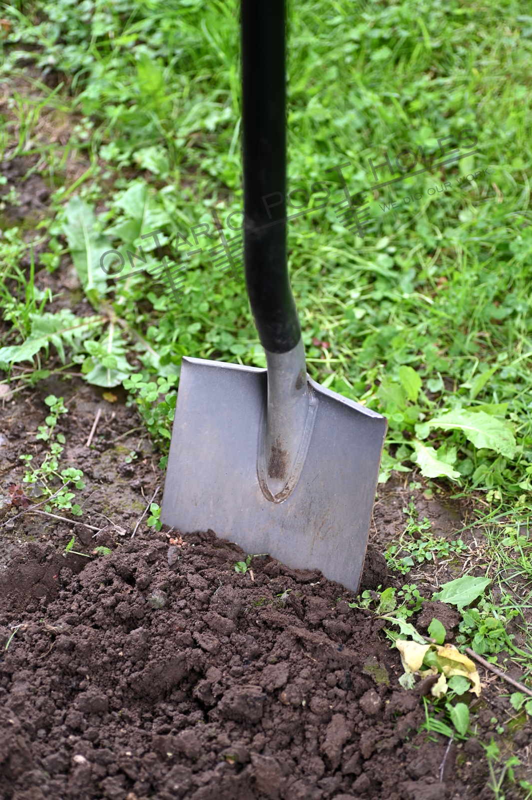 Shovel in soil digging a post hole